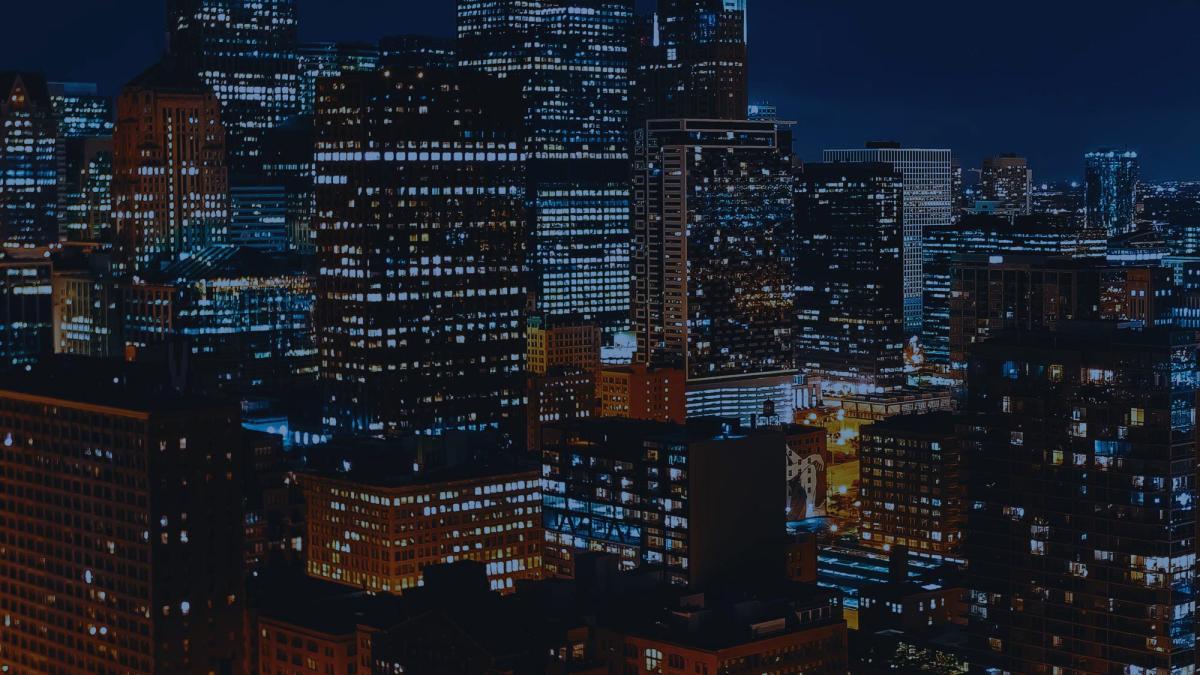 Adobe stock photography of a nighttime cityscape with lighted skyscraper buildings against a night sky.